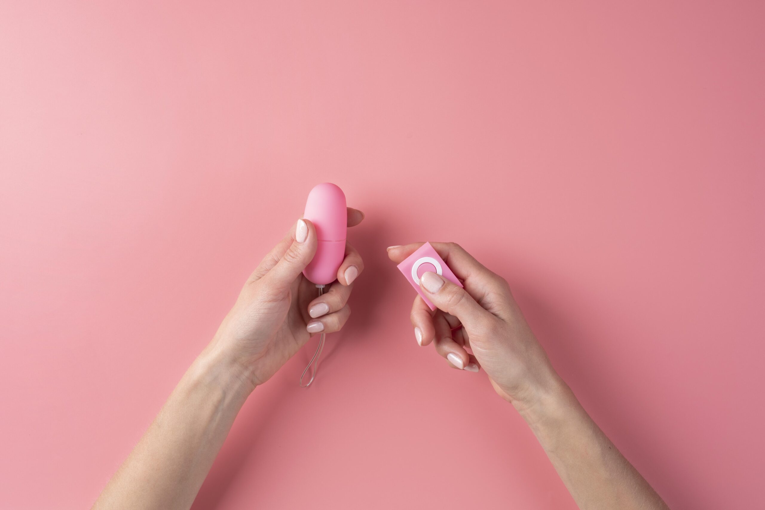 close-up-sex-toy | pleasurable A vibrating love egg in someone's hands on a pink background