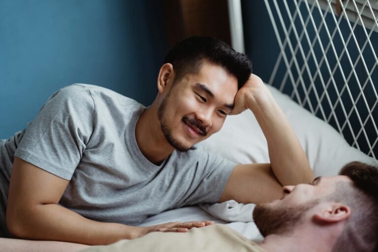 two men in bed looking at each other