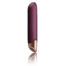Purple vibrator with a rose-gold base standing upright, reflected on a white surface