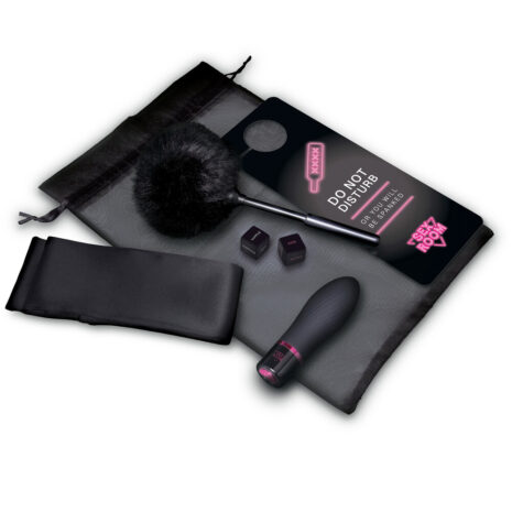 22127x1jpg Adult sex toy kit laid out on a gray mat: black vibrator, fluffy feather wand, blindfold, small dice, and a neon-lit 'Do Not Disturb' card.
