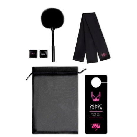 22127x3jpg Bondage kit laid out: fluffy black tickler, two small black cuffs labeled 'KISS' and 'NECK', a long black scarf, a zippered pouch, and a black door hanger stating 'DO NOT ENTER' with 'WE’RE ALL TIED UP' and a pink 'SEX ROOM' logo.