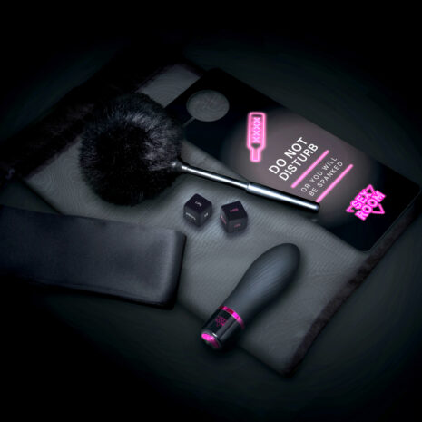 22127x4jpg Sex toy set on a padded surface featuring a black wand vibrator, a fluffy brush, a pair of dice with words, a black blindfold, and a neon-pink sign that says 'DO NOT DISTURB' with a smaller 'SEX ROOM' label nearby.