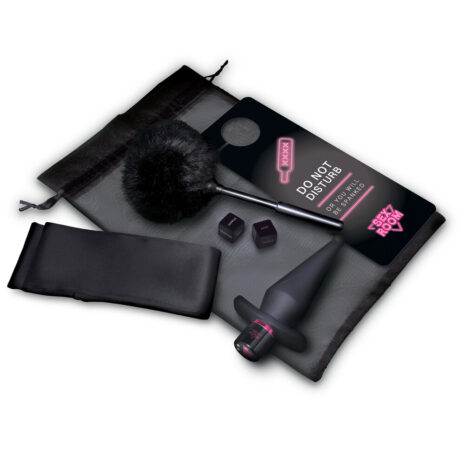 22128x1jpg Sex toy kit on a gray bag: black dildo with pink ring, a wand vibrator with a furry sleeve, blindfold, and small accessories on a padded surface.