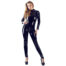 Full-length shot of a woman in a glossy black latex jumpsuit and platform heels against a white background, posing confidently.