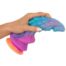 Hand squeezing a blue-to-pink gradient dragon-shaped silicone fidget toy for stress relief
