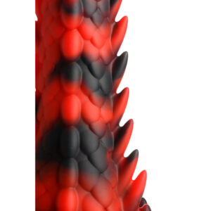 Close-up of red and black scaly texture with jagged edge against white.