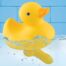 Yellow rubber duck toy floating in water against a blue tiled background.
