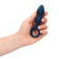 Blue silicone anal plug with a flared base held in a hand.