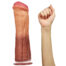 Life-size pink dildo standing upright beside a clenched fist for scale.