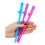 Hand holding three colorful penis-shaped plastic novelty straws (blue, purple, pink).