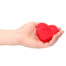 Hand holding a red heart-shaped object with the words 'LOVE HEART' embossed on it.