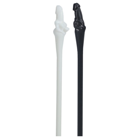 Pair of bone-shaped plastic wands, white and black, with carved figures at the top.