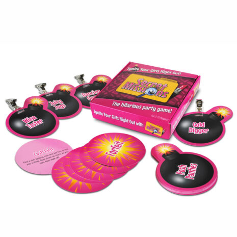 SMGNx1jpg Pink Secret Missions party game box open with round pink mission disks and bomb-shaped tokens scattered nearby.